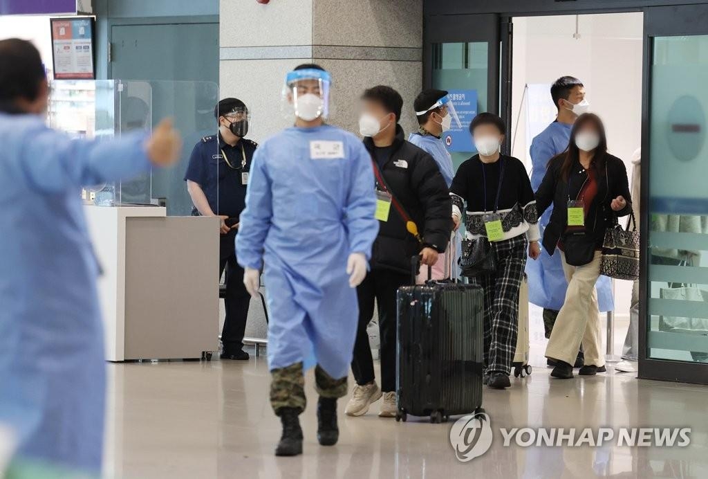 资料图片：2月9日，在仁川国际机场第一航站楼，自华入境人员下机后走向到达大厅。 韩联社