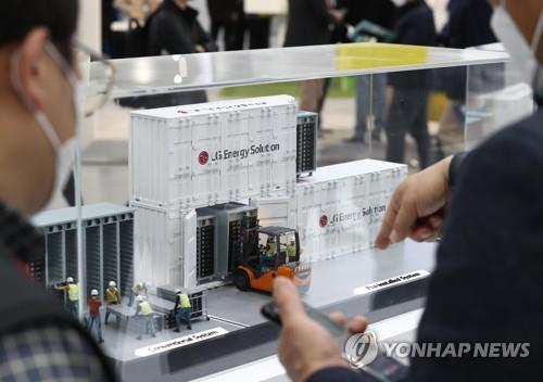 资料图片：2022年3月17日，2022年韩国电池储能展“InterBattery”在位于首尔江南区的韩国国际会展中心（COEX）举行。图为访客正在了解LG新能源展出的储能系统模型。 韩联社