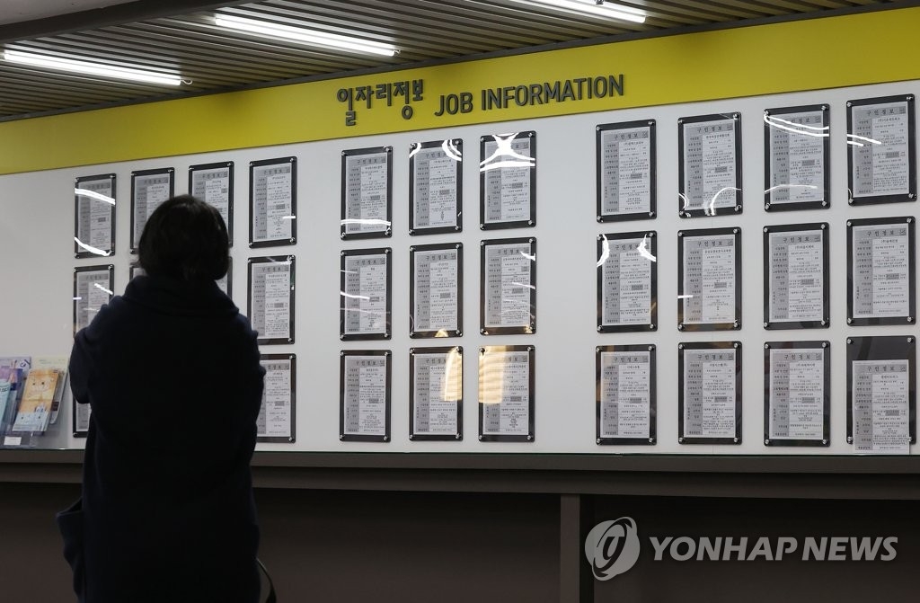 资料图片：求职者查阅招聘公告。 韩联社