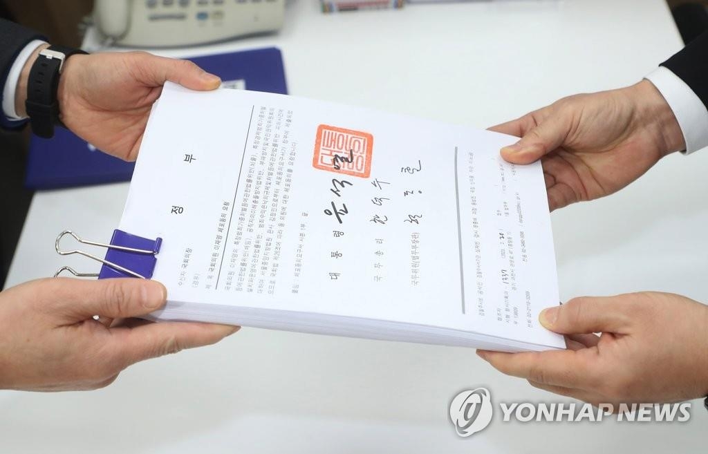 2月21日，在韩国国会议案课，法务部负责人提交法院关于报请国会许可拘留最大在野党共同民主党党首李在明的申请书。总统尹锡悦及政府有关部门负责人已在文件上签字批准法院报请许可。 韩联社/联合采访团