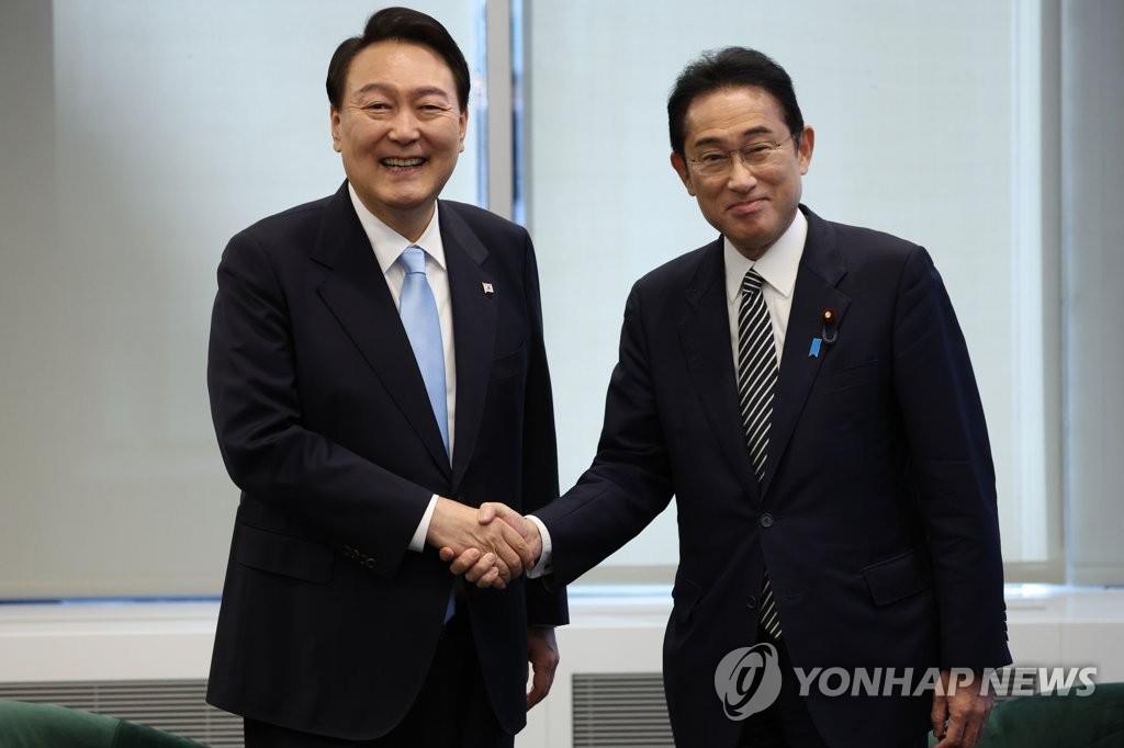 资料图片：当地时间2022年9月21日，在美国纽约，韩国总统尹锡悦（左）和日本首相岸田文雄在会谈前握手合影留念。 韩联社