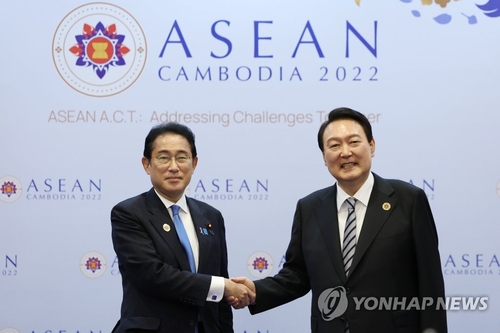 资料图片：当地时间2022年11月13日，在柬埔寨金边，韩国总统尹锡悦（右）同日本首相岸田文雄在会谈前握手合影。 韩联社