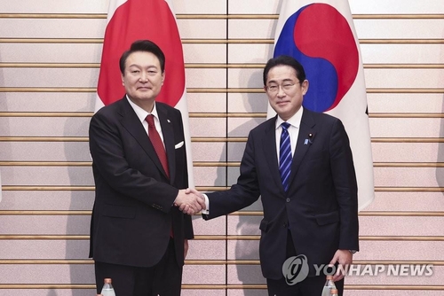 3月16日下午，在日本东京的首相官邸，尹锡悦（左）与岸田文雄举行首脑会谈。图为两位领导人在扩大会谈前握手合影。 韩联社