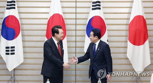 3月16日下午，在日本东京的首相官邸，尹锡悦（左）与岸田文雄举行首脑会谈。图为两位领导人在扩大会谈前握手合影。 韩联社