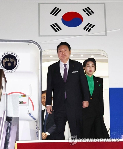 3月17日，在京畿道城南市的首尔机场，韩国总统尹锡悦（左）和夫人金建希结束对日本的访问乘专机返回韩国。图为尹锡悦伉俪正在下机。 韩联社