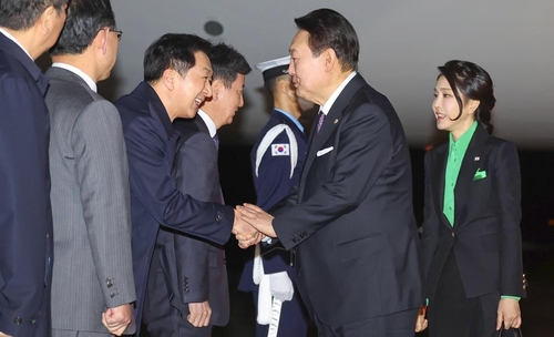 3月17日，在京畿道城南市的首尔机场，韩国总统尹锡悦（右二）和夫人金建希（右一）结束对日本的访问乘专机返回韩国。图为尹锡悦与前来迎接的执政党国民力量党首金起炫握手致意。 韩联社