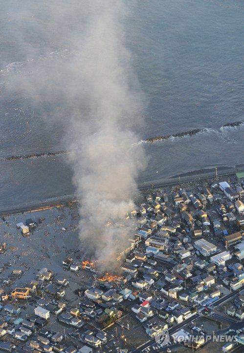 资料图片：2011年3月11日，日本宫城县牡鹿半岛东南部海域发生9级地震。图为地震灾区发生火灾。 韩联社/共同社（图片严禁转载复制）