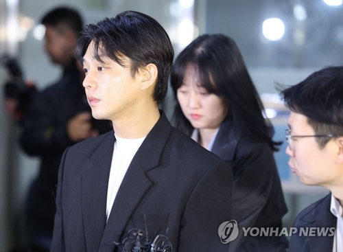 3月27日，在首尔警察厅毒品犯罪侦查队办公楼，涉毒韩星刘亚仁（左一）在警方调查结束后准备离开。 韩联社