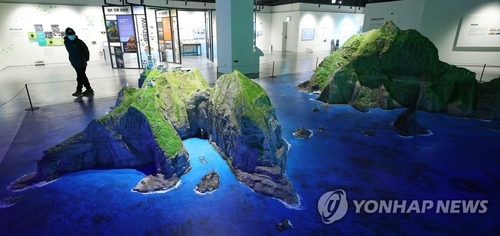资料图片：3月28日，在首尔永登浦区的东北亚历史财团独岛体验馆，访客参观独岛造型。 韩联社