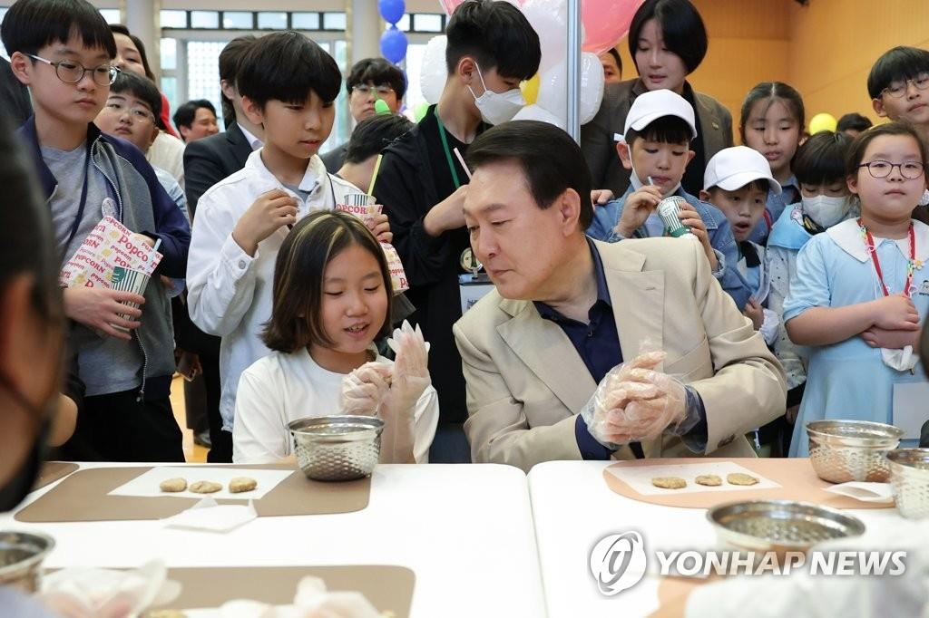 5月5日，在韩国第101个儿童节到来之际，总统尹锡悦邀请儿童青少年到原总统府青瓦台举办庆祝活动。图为尹锡悦与孩子们学做饼干。 韩联社/总统室供图（图片严禁转载复制）