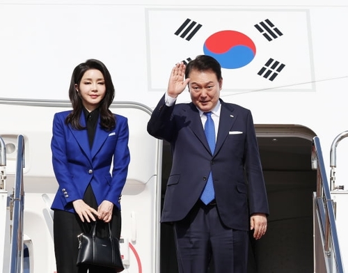 5月21日，在日本广岛机场，韩国总统尹锡悦（右）和夫人金建希女士在结束七国集团（G7）峰会日程后，踏上回国之路。 韩联社