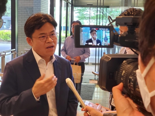5月22日，在日本外务省一楼大厅，刘国熙（左一）在会前接受媒体采访。 韩联社