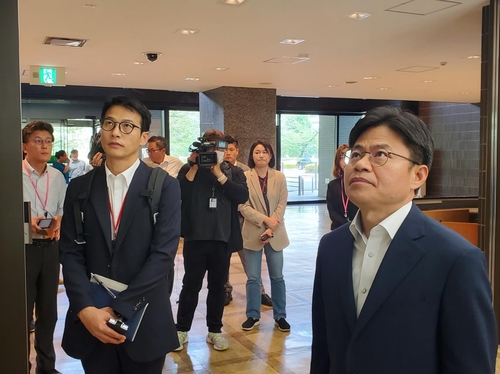 5月22日，在日本外务省，刘国熙（右一）在等电梯。 韩联社