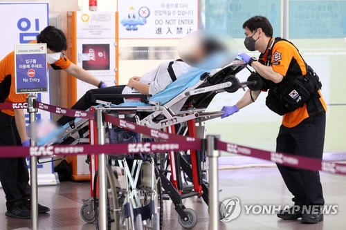 5月26日，在大邱国际机场，韩亚航空OZ8124客机因舱门打开事故紧急降落。图为乘客被送医。 韩联社