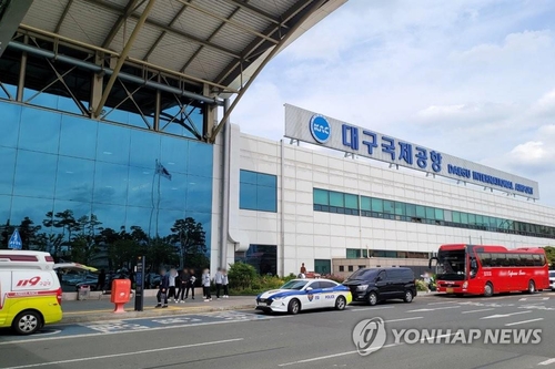 5月26日，在大邱国际机场，韩亚航空OZ8124客机因舱门打开事故紧急降落。图为警车和救护车在机场待命。 韩联社/韩联社TV供图（图片严禁转载复制）