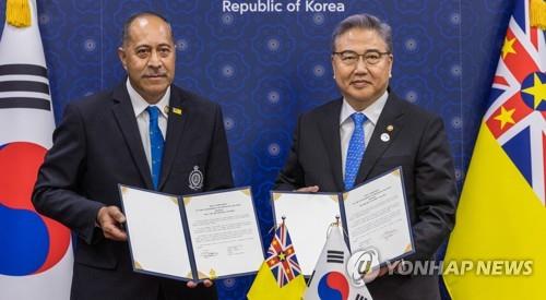 5月29日，在首尔外交部大楼，韩国外交部长官朴振（右）和纽埃总理兼外长塔格拉吉手举建交文件合影。 韩联社