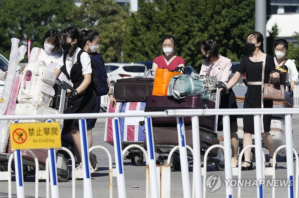 资料图片：8月22日，在中国北京首都机场，朝鲜居民前往航站楼准备出镜。 韩联社/共同社（图片严禁转载复制）