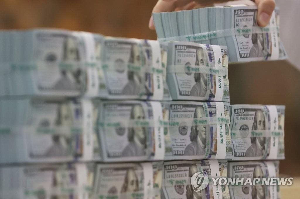 资料图片：韩亚银行的职员正在查点外币。 韩联社