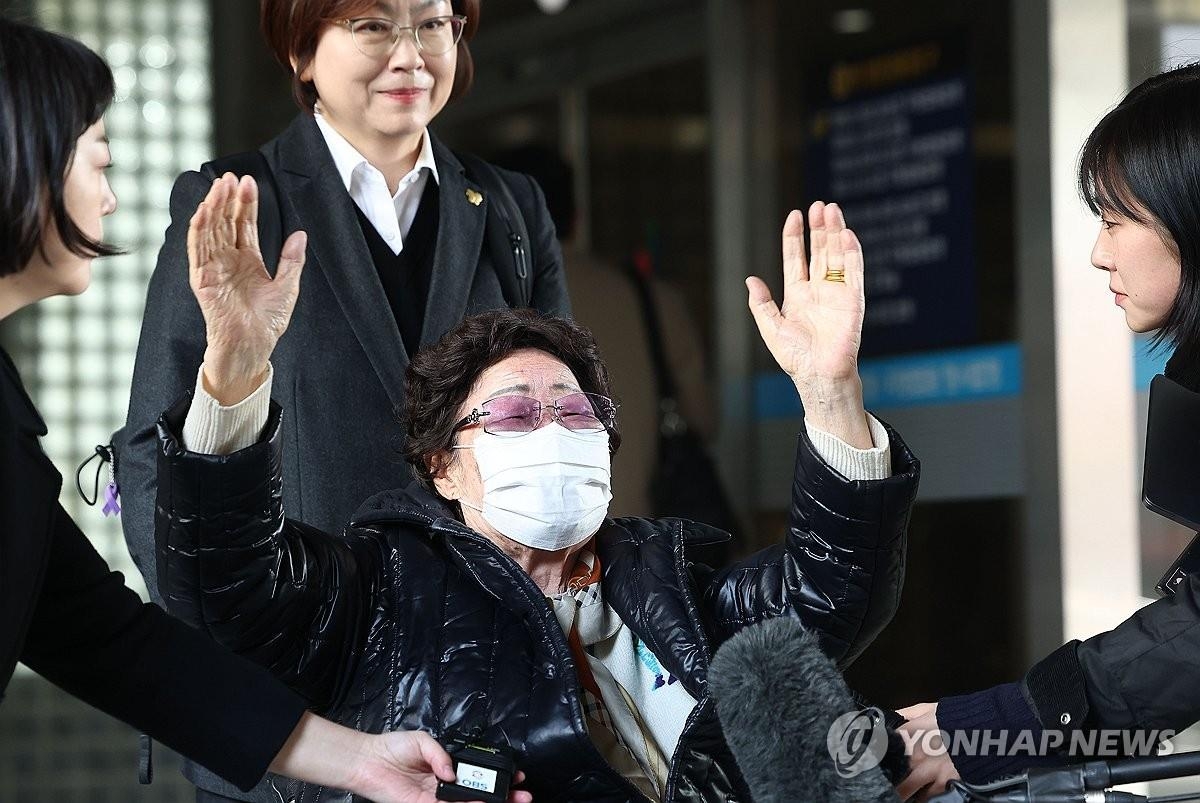 资料图片：11月23日，在首尔瑞草区的首尔高等法院，慰安妇受害者李容洙（轮椅）高举双手庆祝索赔案胜诉。 韩联社