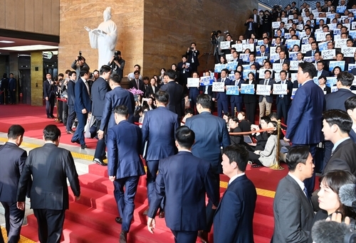 资料图片：10月31日，在国会，最大在野党共同民主党议员齐举手牌抵制总统尹锡悦。 韩联社/联合采访团