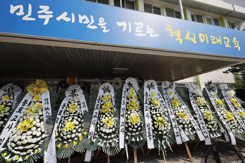 资料图片：在首尔江南瑞草教育厅前的焚香场所，教师们献上花圈悼念轻生小学教师。图片摄于7月21日。 韩联社