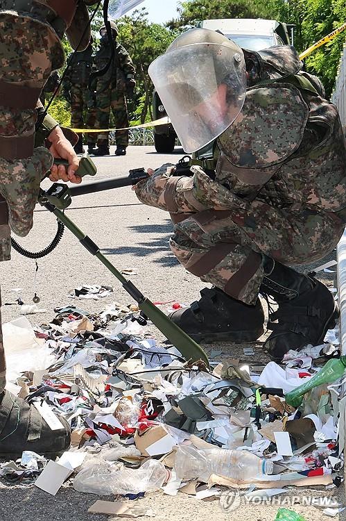 资料图片：6月2日，在仁川市中区，韩军士兵用地雷探测器对朝鲜“垃圾气球”的装载物进行探测。 韩联社