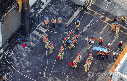 6月24日，位于京畿道华城市的一次电池制造商ARICELL工厂发生火灾。图为消防队员进行遗体收敛工作。 韩联社/联合采访团