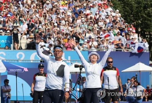 当地时间8月2日，在巴黎荣军院广场，韩国射箭运动员金优镇（左）和林是见庆祝夺冠。 韩联社