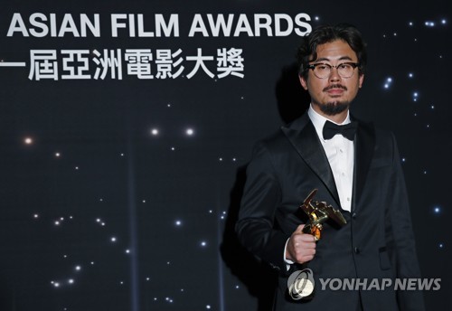 3月21日，在香港，罗泓轸在亚洲电影大奖颁奖典礼上摆姿势供媒体拍照。（韩联社）