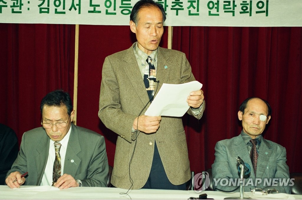 资料图片：1995年，咸世焕（中）举行记者会，要求让其返回朝鲜。 韩联社
