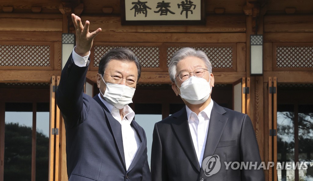 10月26日，在青瓦台常春斋，韩国总统文在寅（左）同执政党总统候选人李在明合影留念。 韩联社