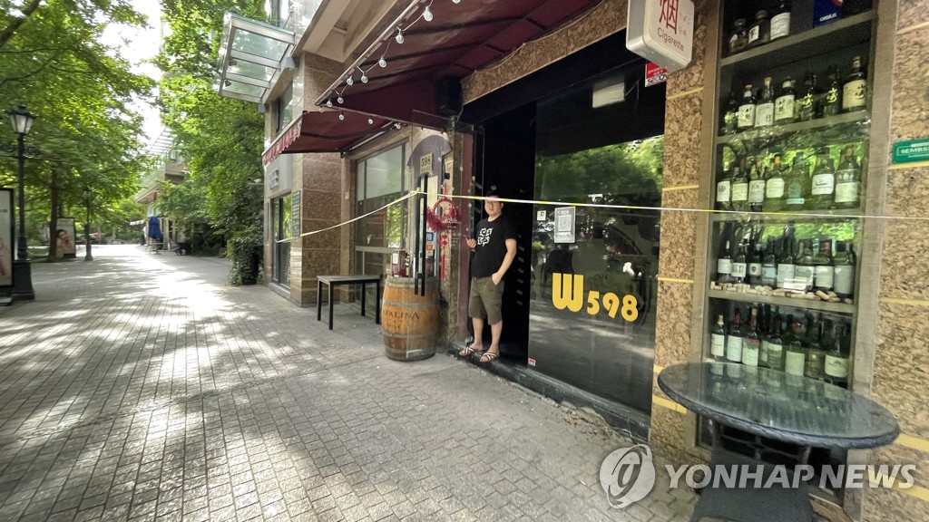 资料图片：图为上海市区一条街的商店关门歇业，摄于2022年5月19日。 韩联社