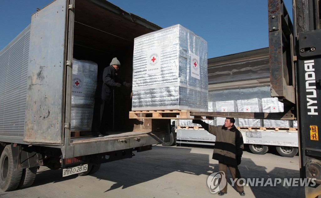 资料图片：2009年12月，韩方将40万人份达菲和10万人份乐感清分别装在8辆运送车通过军事分界线抵达开城送至朝方。（韩联社/统一部供图）