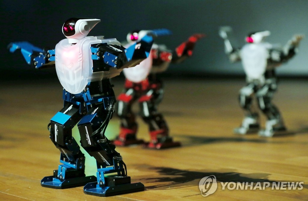 资料图片：2014年8月5日，“2014年全球机器人营地”（Global Robot Camp）开幕式在仁川市松岛国际大学举行。图为一组机器人在进行舞蹈表演。（韩联社）