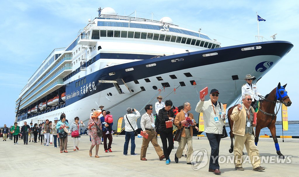 资料图片：2015年5月16日，在济州，中国游客走下邮轮前往目的地。 韩联社