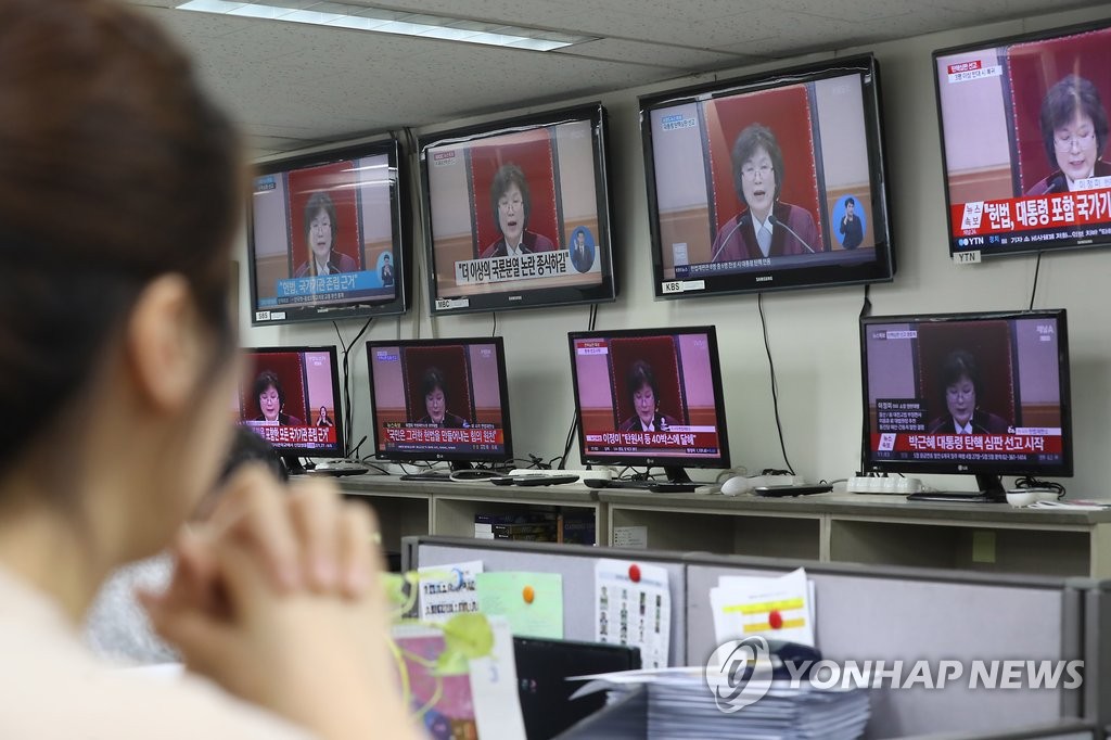 图为市民观看朴槿惠弹劾案审判直播。（韩联社）