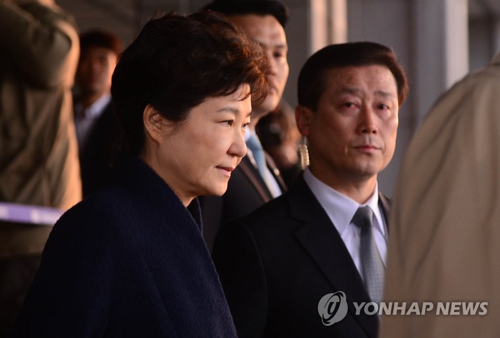 3月22日，朴槿惠（左一）走出首尔中央地方检察厅，准备乘车回家。（韩联社）