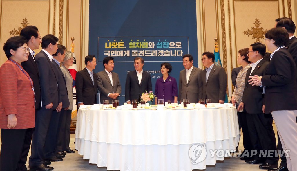 7月20日，在韩国青瓦台，与会人士在国家财政战略会议上亲切交谈。（韩联社）
