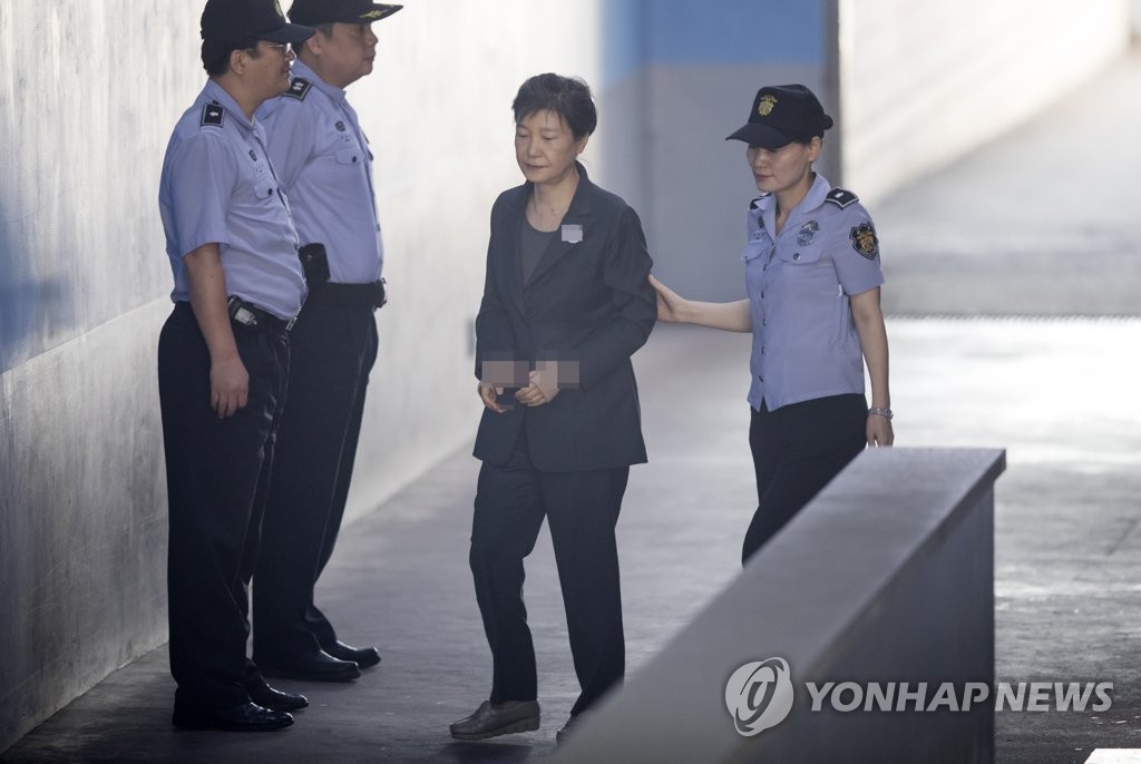 资料图片：2017年9月26日，朴槿惠（右二）前往首尔中央地方法院出庭受审。 韩联社