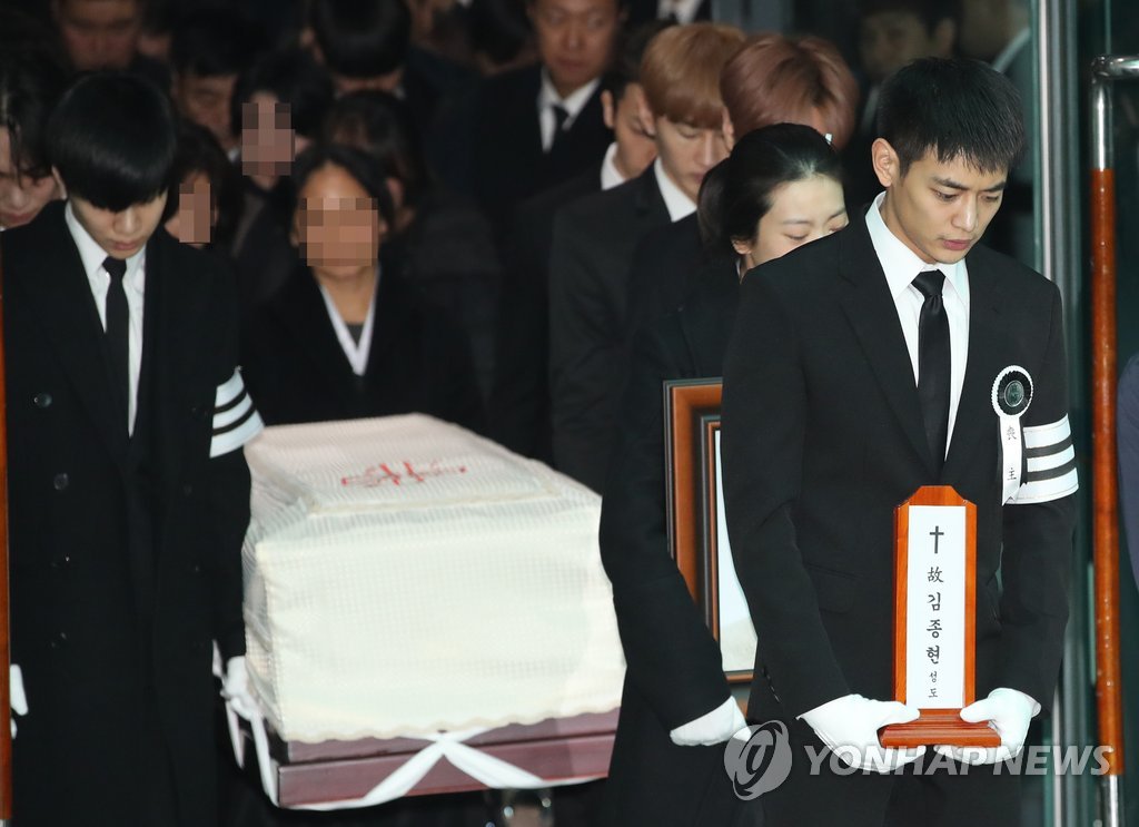 12月21日上午，在首尔峨山医院，SHINee成员珉豪（右）手捧钟铉的牌位。(韩联社）
