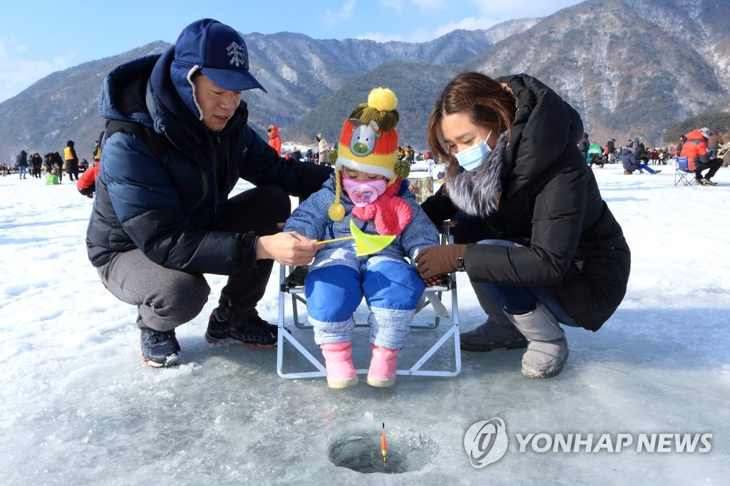 资料图片：举家出游体验冰钓。（韩联社）