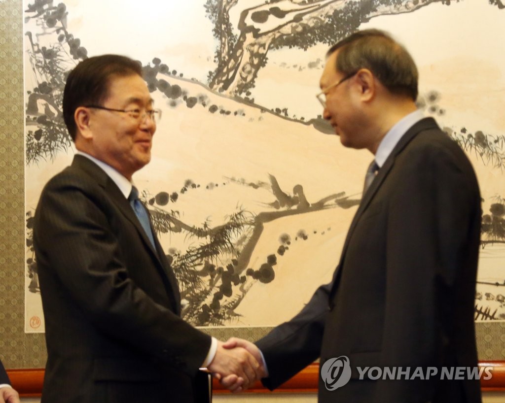 3月12日，在中国北京，郑义溶（左）与杨洁篪亲切握手。（韩联社）
