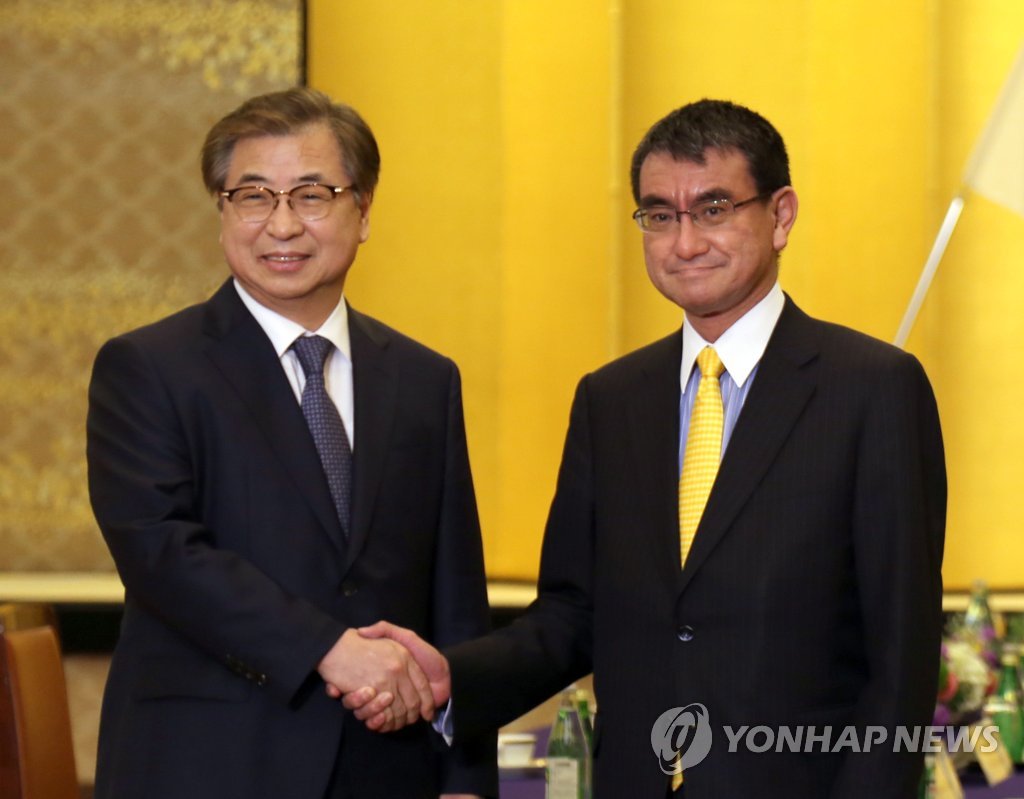 韩总统特使与日本外务大臣握手