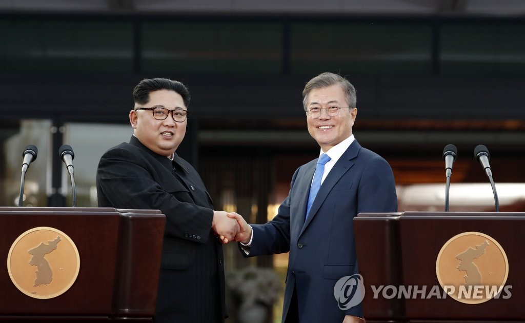 资料图片：4月27日，在韩朝边境板门店，韩国总统文在寅（右）与朝鲜国务委员会委员长金正恩发表《板门店宣言》后握手合影。（韩联社）