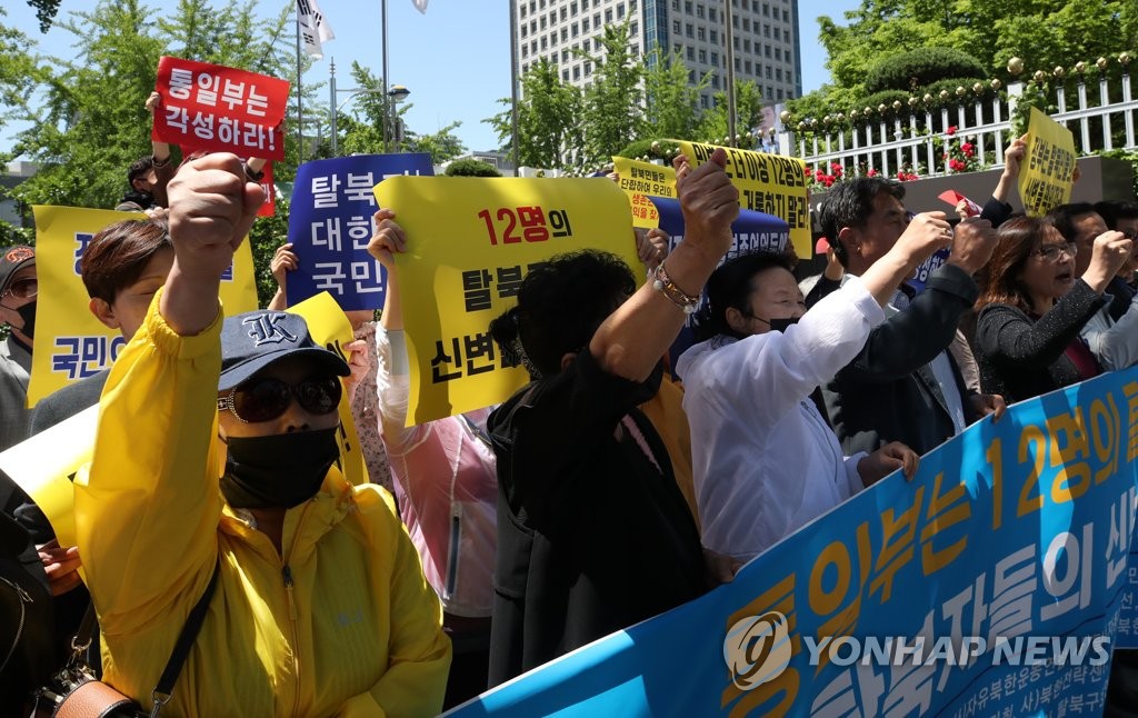 资料图片：5月19日上午，脱北者团体成员在韩国中央政府大楼前举行记者会，反对送还朝鲜餐厅员工。（韩联社）