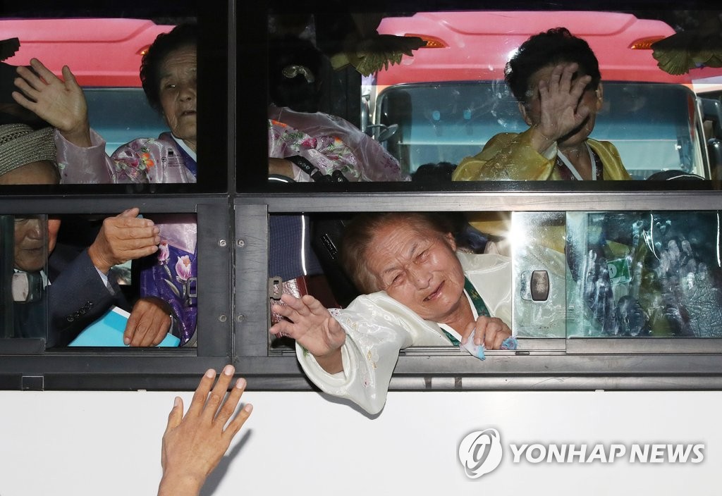 8月26日，在朝鲜金刚山酒店，参加韩朝离散家属团聚活动的朝方探亲团乘车离开并同韩方亲人挥泪道别。（韩联社/新闻通讯采访团）