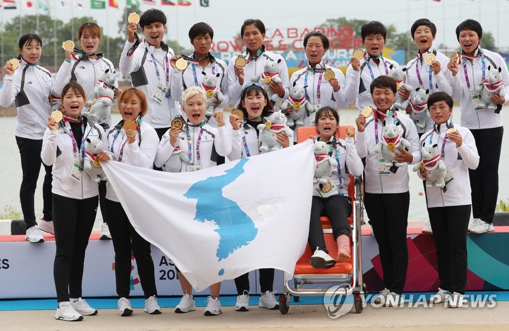 当地时间8月26日，在印尼巨港，韩朝联队在雅加达亚运会女子龙舟500米决赛中摘得金牌后合影留念。（韩联社）