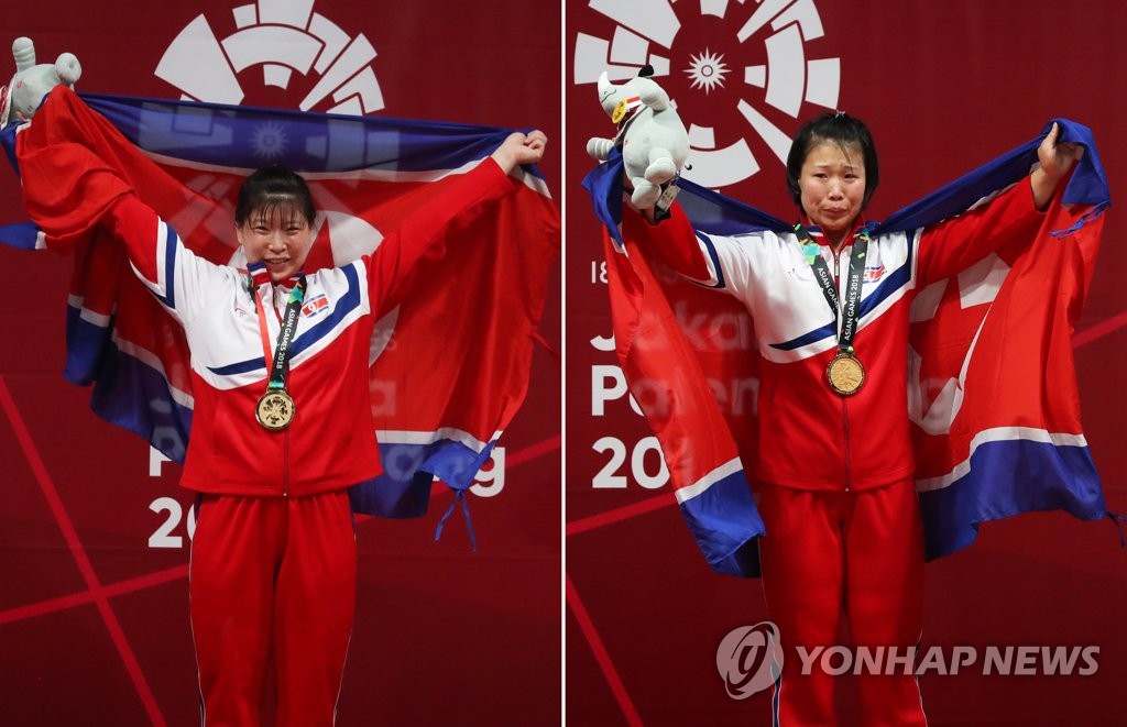 资料图片：当地时间2018年8月26日，在雅加达亚运会举重比赛中，朝鲜女选手林贞心（左）夺得75公斤级冠军。前日，另一朝鲜女选手林银心获得69公斤级冠军。韩联社