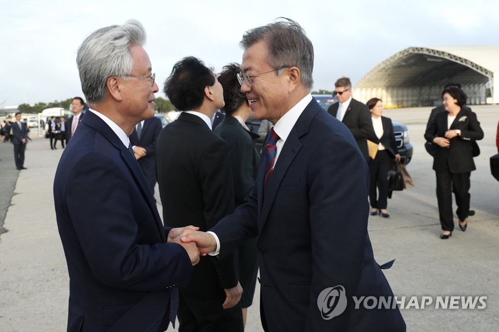 当地时间9月26日，在纽约肯尼迪国际机场，韩国总统文在寅（右）在乘机前与韩国驻美国大使赵润济握手致意。（韩联社）
