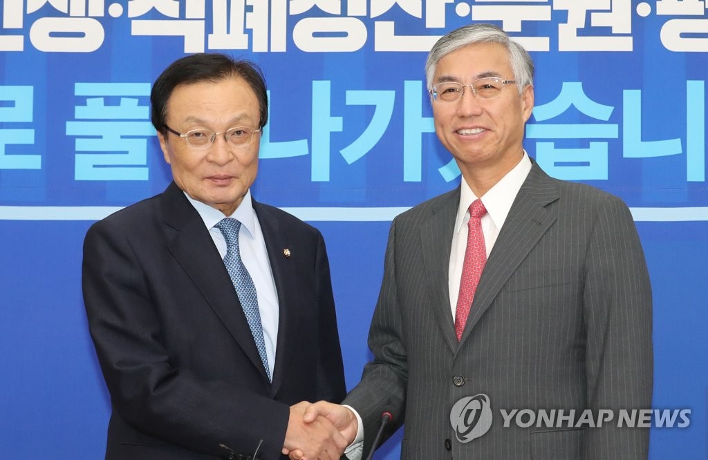 9月28日下午，在韩国国会，共同民主党党首李海瓒（左）与中国驻韩国大使邱国洪握手合影。（韩联社）